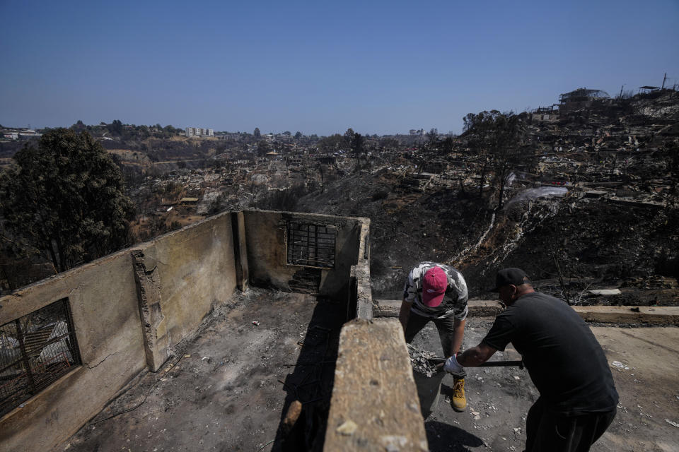 Residents clean up amid the rubble of homes burned by deadly forest fires in Vina del Mar, Chile, Monday, Feb. 5, 2024. (AP Photo/Esteban Felix)