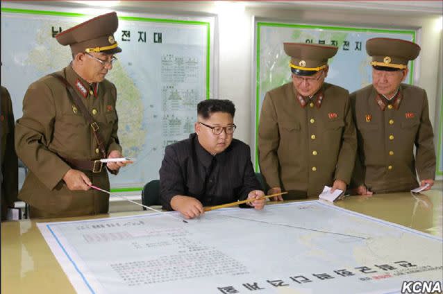 North Korean leader Kim Jong-un and his top military brass reportedly reviewing attack plans for Guam. Source: North Korean state media