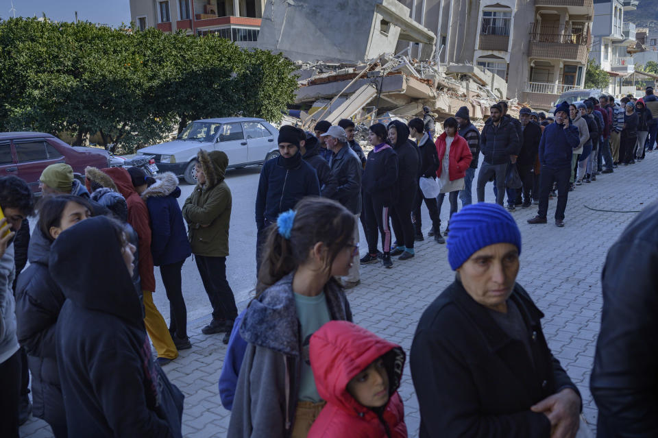 Residents wait in a queue outside a bakery that gives out free bread in Samandag, south of Hatay on February 16, 2023, ten days after a 7.8-magnitude struck the border region of Turkey and Syria.