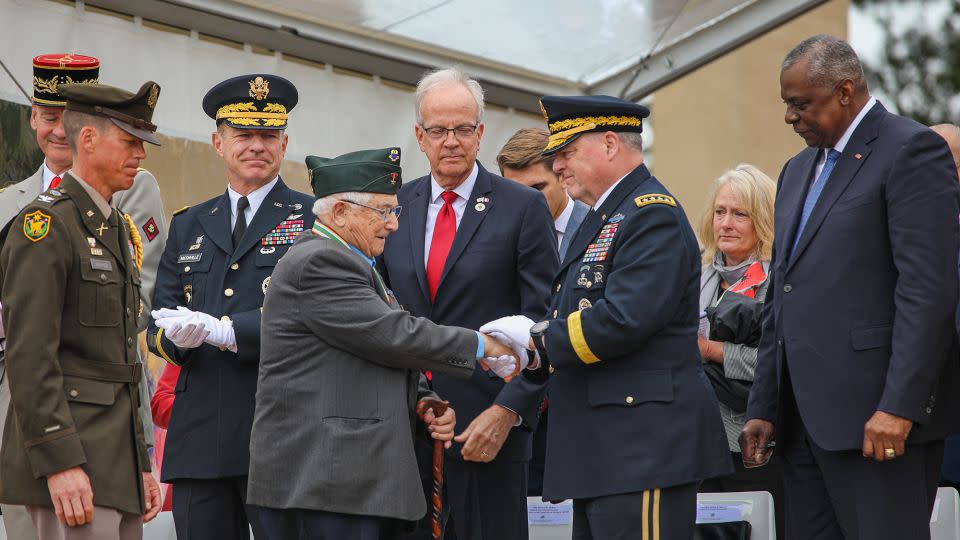 World War II veteran Jack Foy shakes the hand of the then-chairman of the Joint Chiefs of Staff, Gen. Mark A. Milley, at last year's D-Day anniversary. - 1st Lt. Katherine Sibilla