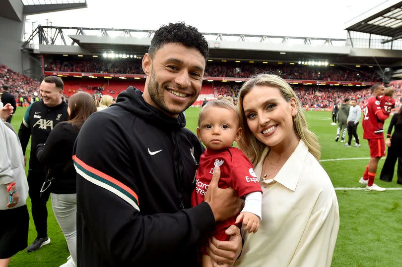 Alex Oxlade-Chamberlain of Liverpool posing for a photograph with Perrie Edwards and their baby boy at the end of the Premier League match between Liverpool and Wolverhampton