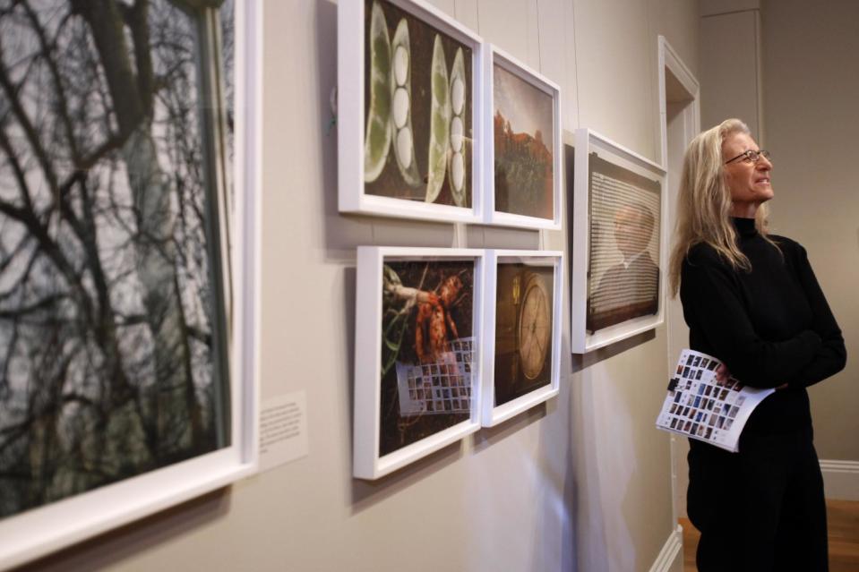 Photographer Annie Leibovitz leads a media tour of her exhibit "Pilgrimage" Tuesday, Jan. 24, 2012, at the Smithsonian American Art Museum in Washington. Reflected in the glass is exhibition curator Andy Grundberg. (AP Photo/Jacquelyn Martin)