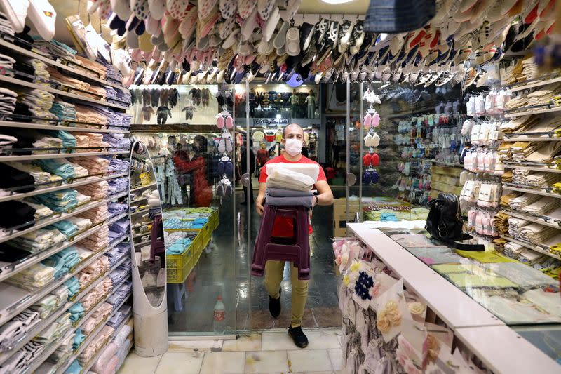 An Iranian man wears a protective mask, amid the outbreak of the coronavirus disease (COVID-19), at his store in Tehran