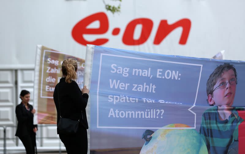 Protestors hold banners outside the venue for the annual meeting of German utility giant E.ON in Essen