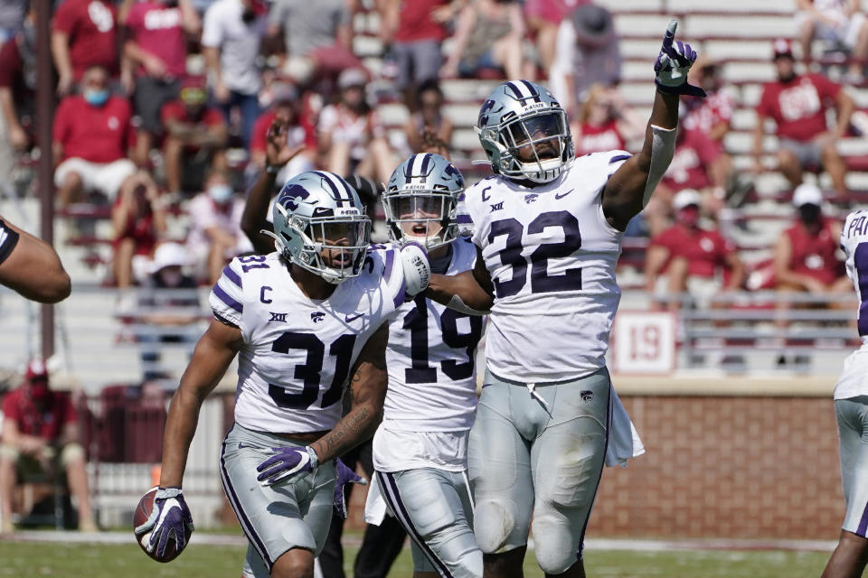 Kansas State defensive back Jahron McPherson (31) celebrates with teammates Ross Elder (19) and Justin Hughes (32) after an interception to seal the win over Oklahoma in the second half of an NCAA college football game Saturday, Sept. 26, 2020, in Norman, Okla. (AP Photo/Sue Ogrocki).