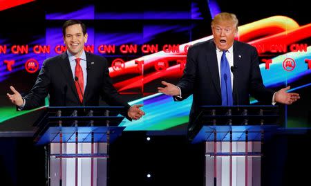 Republican U.S. presidential candidates Marco Rubio (L) and Donald Trump react to each other as they discuss an issue during the debate sponsored by CNN for the 2016 Republican U.S. presidential candidates in Houston, Texas, February 25, 2016. REUTERS/Mike Stone