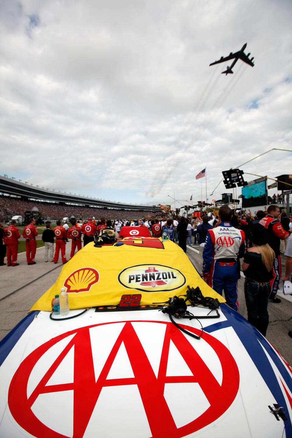 FORT WORTH, TX - NOVEMBER 06: Kurt Busch, driver of the #22 AAA Dodge, stands for the national anthem as a B-52 bomber flys over the track during pre-race activities prior to the start of the NASCAR Sprint Cup Series AAA Texas 500 at Texas Motor Speedway on November 6, 2011 in Fort Worth, Texas. (Photo by Chris Graythen/Getty Images)