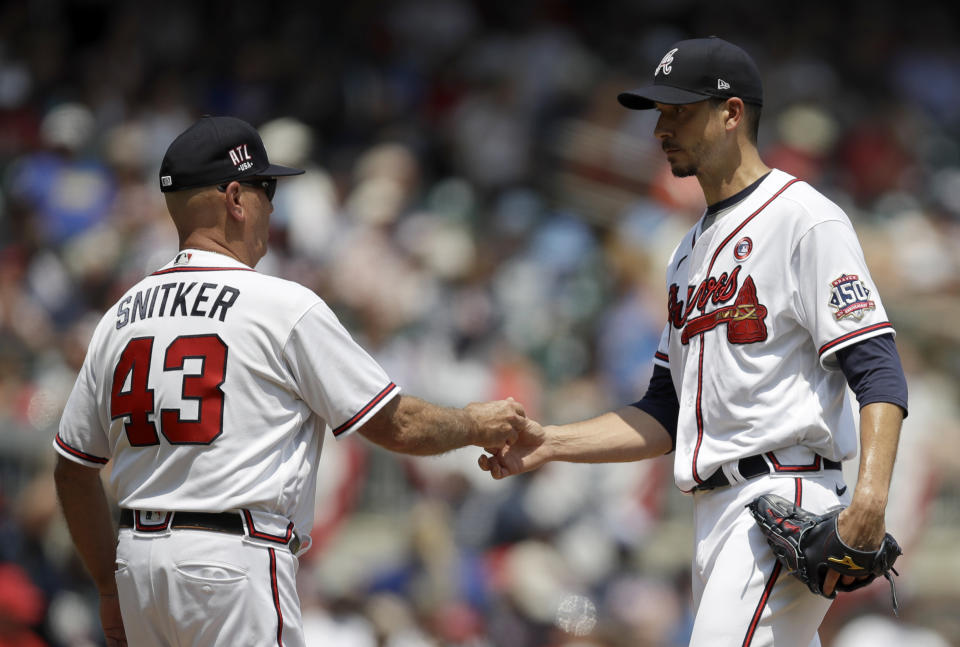 Atlanta Braves pitcher Charlie Morton, right, hands the ball to manager Brian Snitker (43) in the sixth inning of a baseball game against the Miami Marlins, Sunday, July 4, 2021, in Atlanta. (AP Photo/Ben Margot)