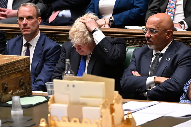 Boris Johnson (centro), flanqueado por el secretario de Justicia y viceprimer ministro de Gran Bretaña, Dominic Raab (izquierda), y el nuevo ministro de Hacienda de Gran Bretaña, Nadhim Zahawi (derecha), durante las preguntas del primer ministro en la Cámara de los Comunes, ayer 