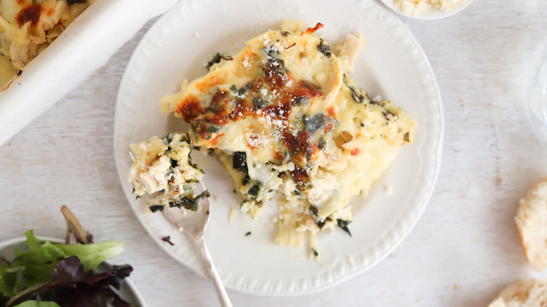 spinach and chicken lasagna piece on white pate