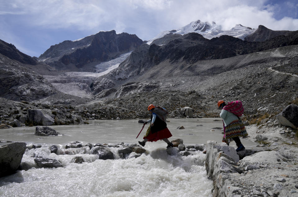 Suibel Gonzales, left, and her mother Lidia Huayllas, Aymara Indigenous women who make a living as mountain guides, walk on the Huayna Potosi glacier on the outskirts of El Alto, Bolivia, Sunday, Nov. 5, 2023. When they first started climbing the Andes peaks years ago, they could hear the ice crunching under their crampons. These days, it’s the sound of melted water running beneath their feet that they mostly listen to as they make their way up. (AP Photo/Juan Karita)