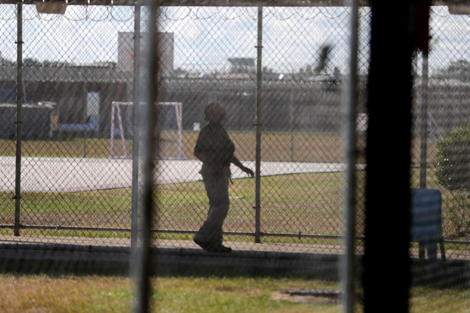 A guard walks on a path between yards during a media tour inside the Winn Correctional Center in Winnfield, La., Thursday, Sept. 26, 2019. Formerly a medium-security prison, Winn has a dining hall, outdoor soccer fields, a gymnasium, and a 200-person chapel built by former inmates. (AP Photo/Gerald Herbert)