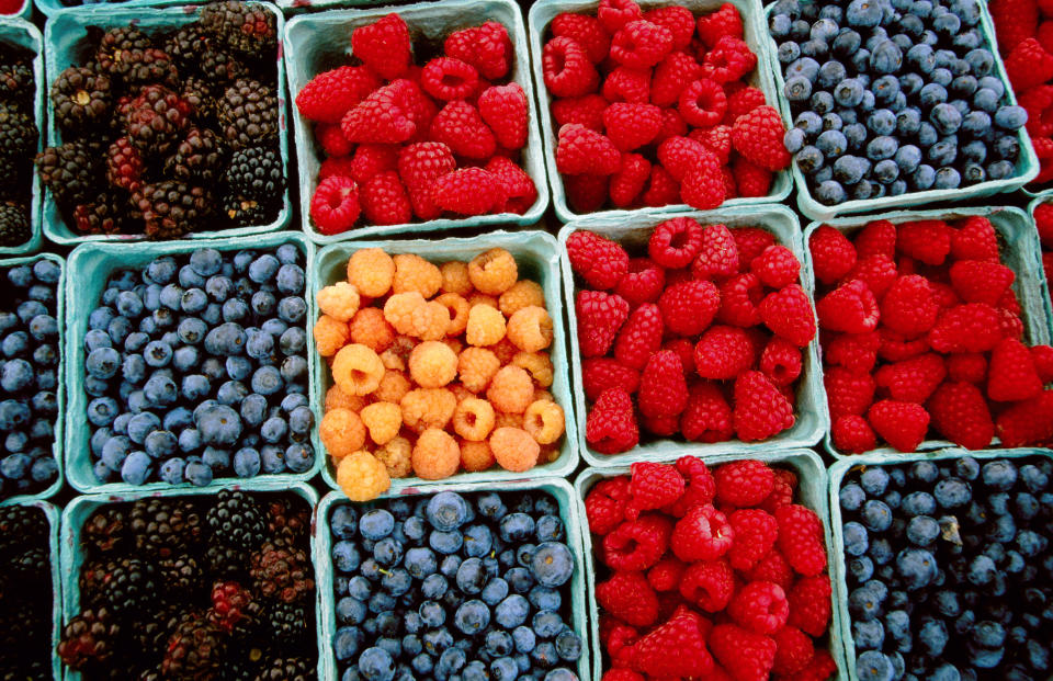 Punnets of raspberries, blueberries, and blackberries at a farmer's market