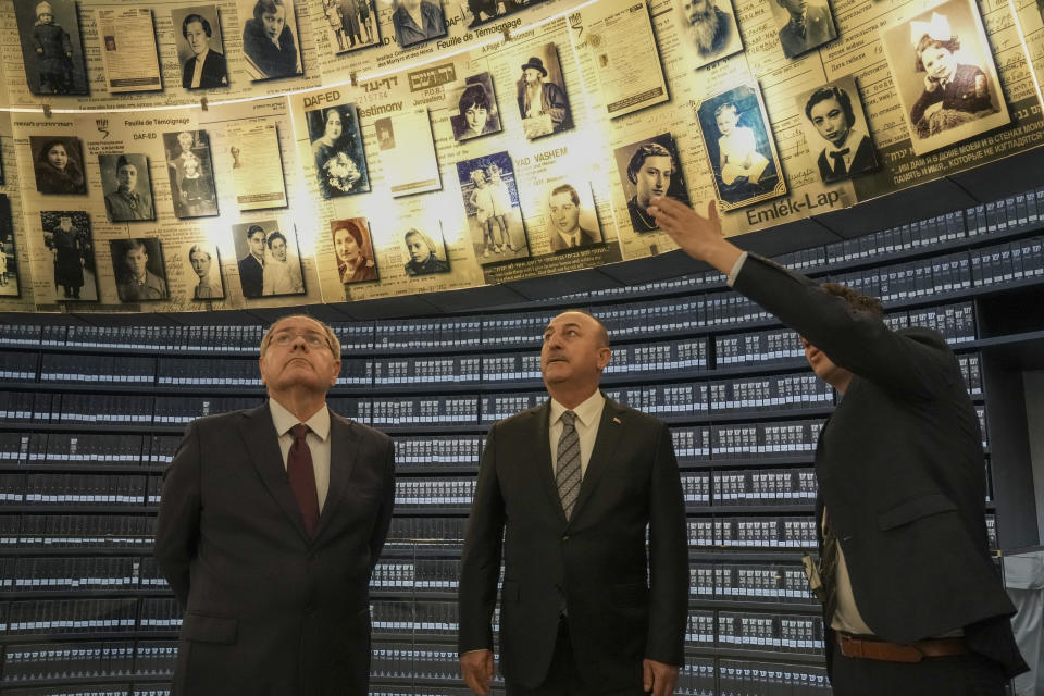 Turkish Foreign Minister Mevlut Cavusoglu, center, visits with Dani Dayan, Yad vashem chairman, left, at the Hall of Names in the Yad Vashem World Holocaust Remembrance Center in Jerusalem, Wednesday, May 25, 2022. (AP Photo/ Maya Alleruzzo)