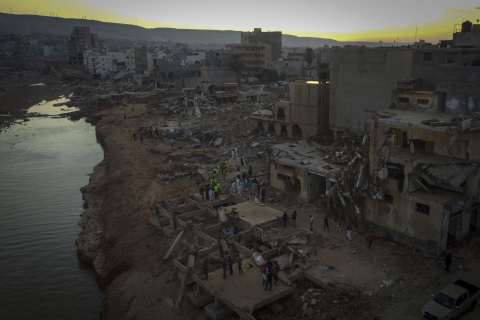 Varias personas buscan a víctimas de las inundaciones entre los escombros en Derna, Libia, el 15 de septiembre de 2023. (AP Foto/Ricardo García Vilanova)