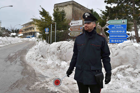 A Carabinieri paramilitary policeman patrols in the town of Farindola, central Italy, following a series of earthquakes and a snow avalanche hitting a hotel in central Italy, January 20, 2017. REUTERS/Emiliano Grillotti