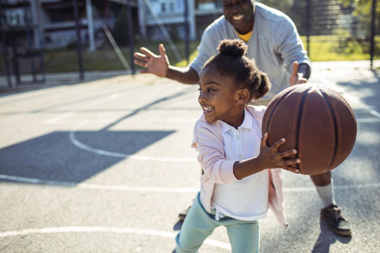 grandfather and grandkid playing basketball