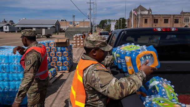 PHOTO: A member of the National Guard places a case of water in the back of a car at the State Fair Grounds in Jackson, Miss., Sept. 2, 2022.  (Seth Herald/AFP via Getty Images)