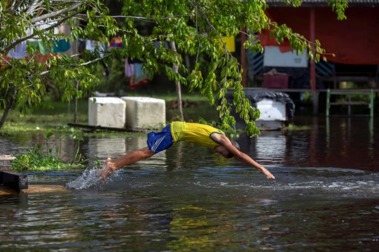 A boy enjoys the river in the Brazilian village of Sao Raimundo do Jaraua -- learning to swim in the Amazon river basin also means learning to avoid piranhas and caimans