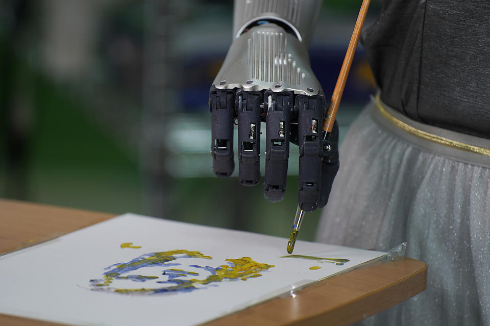 Sophia uses a brush to paint at Hanson Robotics studio in Hong Kong on March 29, 2021. Sophia is a robot of many talents, she speaks, jokes, sings and even makes art. In March, she caused a stir in the art world when a digital work she created as part of a collaboration was sold at an auction for $688,888 in the form of a non-fungible token (NFT). (AP Photo/Vincent Yu)