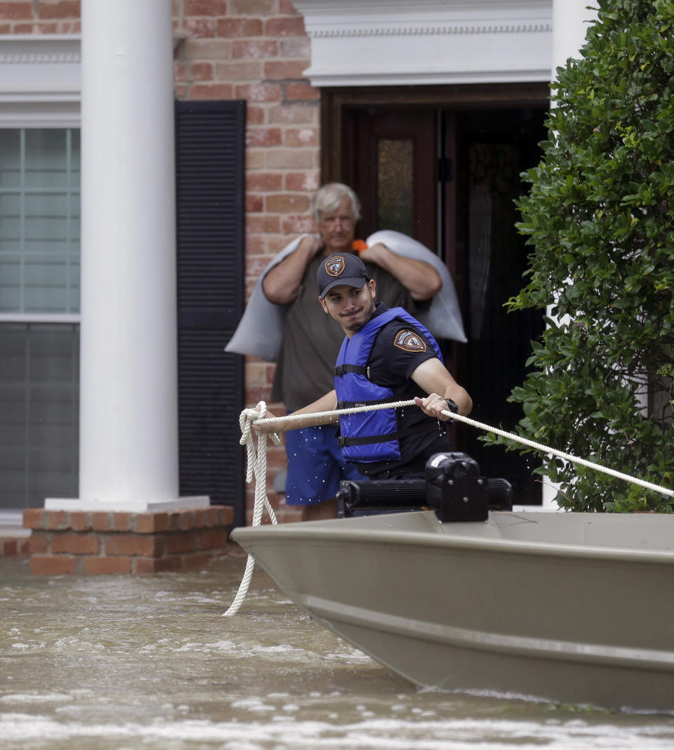 Harris County Sheriff's Office deputy J. Herrera pulls a boat closer to evacuate Larry LeBlanc from his flooded home Friday, Sept. 20, 2019, in Huffman, Texas. Emergency workers used boats Friday to rescue about 60 residents of a Houston-area community still trapped in their homes by floodwaters following one of the wettest tropical cyclones in U.S. history. (Godofredo A. Vásquez/Houston Chronicle via AP)