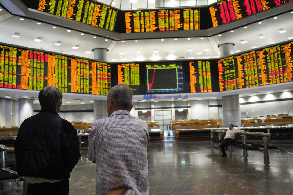 Visitors stand in front of private stock trading boards at a private stock market gallery in Kuala Lumpur, Malaysia, Friday, March 15, 2019. Shares were higher Friday in Asia after a day of lackluster trading on Wall Street. (AP Photo/Yam G-Jun)