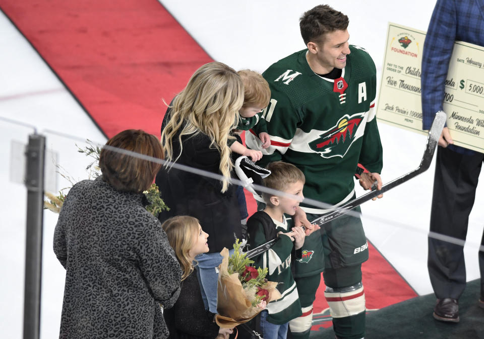 Minnesota Wild's Zach Parise, right, poses with his family and a silver stick emblematic of play in 1,000 career hockey game prior to the Wild's game against the San Jose Sharks in an NHL hockey game, Saturday, Feb. 15, 2020, in St. Paul, Minn. (AP Photo/Tom Olmscheid)