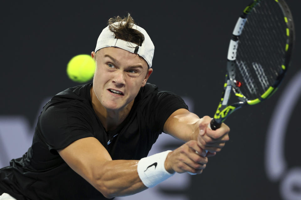 Holger Rune of Denmark plays a shot in his match against Max Purcell of Australia during the Brisbane International tennis tournament in Brisbane, Australia, Monday, Jan. 1, 2024. (AP Photo/Tertius Pickard)