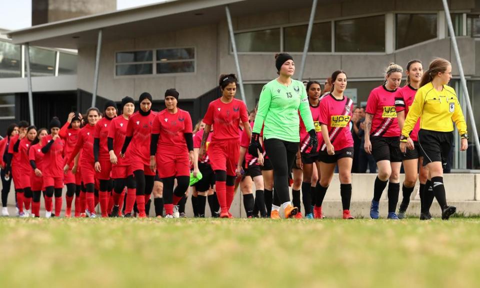 Melbourne Victory AWT players walk on the pitch with players from Melton Phoenix before a game in Australia’s seventh tier in May 2022.