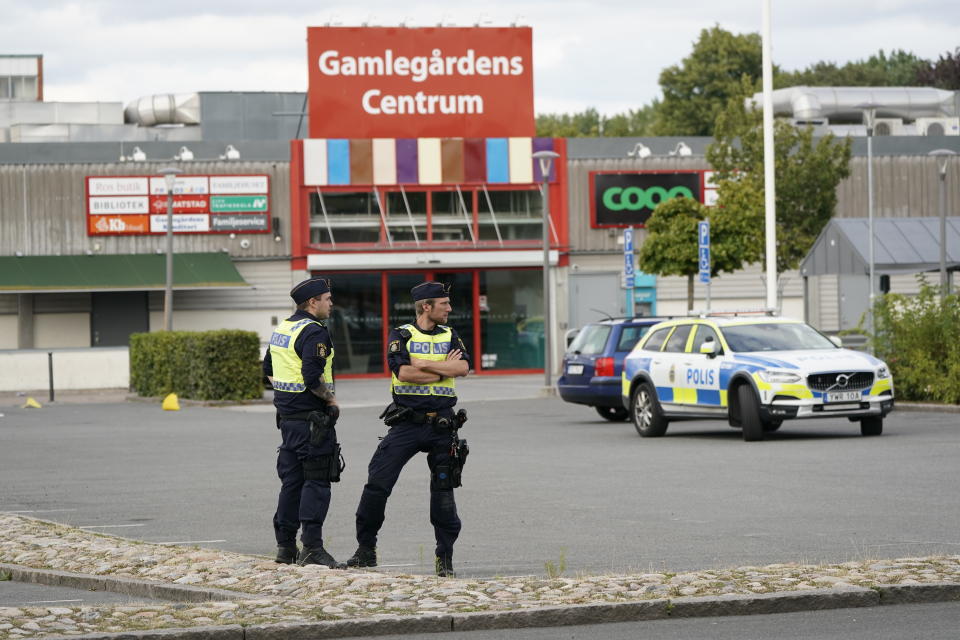 Poolice stand at the scene of a shooting incident, in the Nasby area, of Kristianstad, Sweden, Tuesday, Aug. 3, 2021. Police say that at least two people have been injured in a shooting in the southern Swedish city of Kristianstad. Swedish police received an alert on Tuesday afternoon that several loud bangs had been heard. According to preliminary information, no one was killed. (Johan Nilsson/TT News Agency via AP)