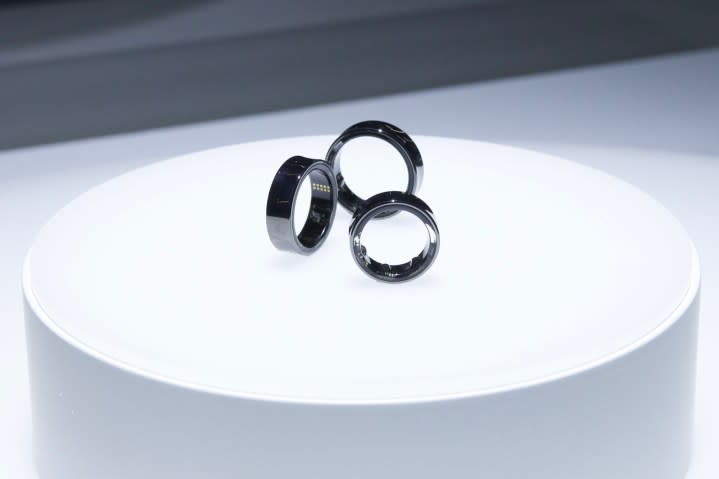 Three sizes of the Samsung Galaxy Ring, sitting on top of a white display case.