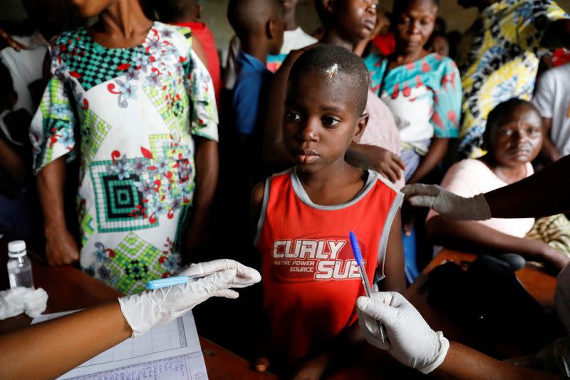 FILE PHOTO: Health workers attend to Majesty Frank, who said he hit his head when he fell into a ditch while he was wading through the flood water from his community to the relief camp in Ogbogu, Rivers state