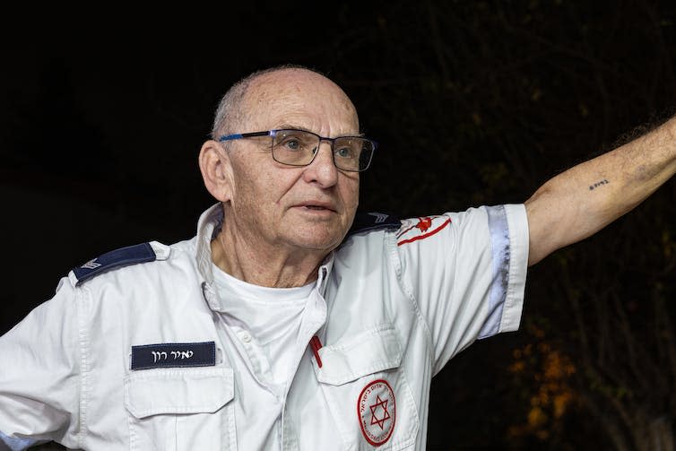 A man in a uniform holds up his arm.