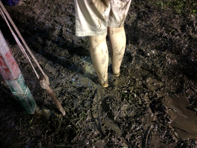 A rally goer braves the wet and muddy field.