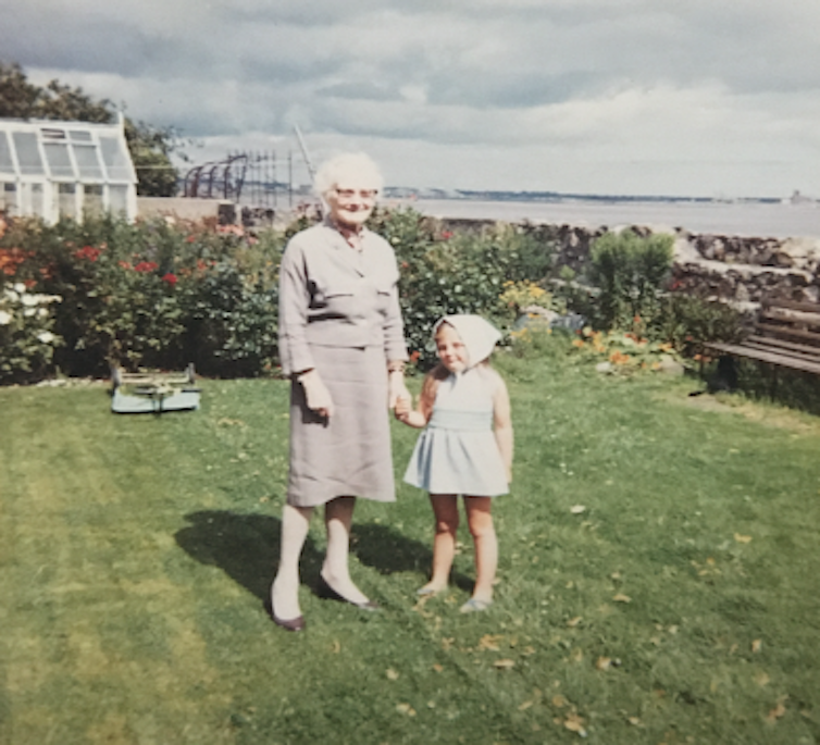 A grandmother holds hands with her granddaughter.