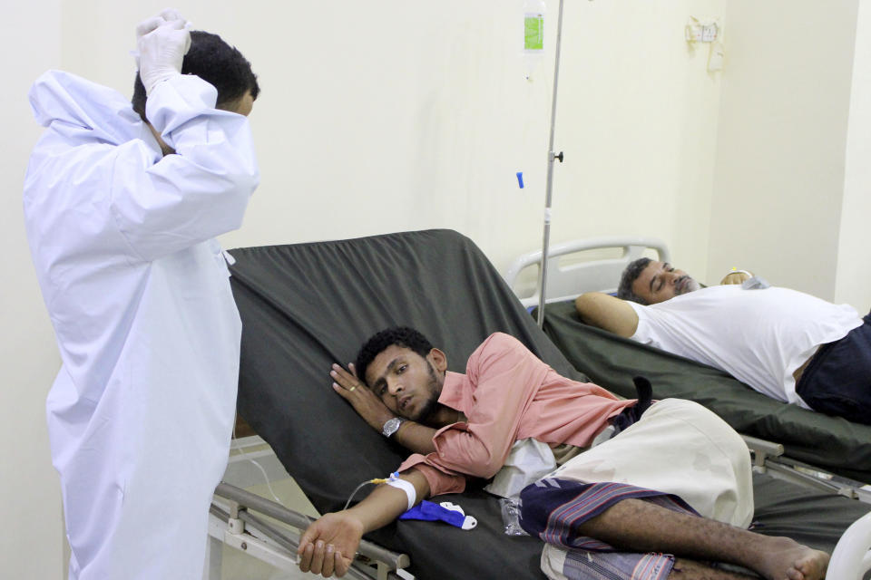 In this May 12, 2020 photo, a Yemeni doctor talks to a patient receiving treatment and lying on a bed at a hospital in Aden, Yemen. People have been dying by the dozens each day in southern Yemen's main city, Aden, many of them with breathing difficulties, say city officials. Blinded with little capacity to test, health workers fear the coronavirus is running out of control, feeding off a civil war that has completely broken down the country. (AP Photo/Wail al-Qubaty)