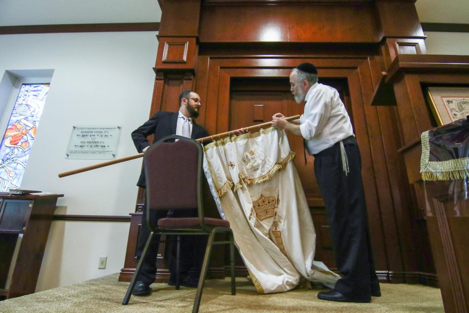 Rabbi Chuni Vogel and Rabbi Motti Flikshtein prepares to hang a parochet during preparations for Rosh Hashanah at the Chabad Center for Jewish Life on Sunday, Oct. 2, 2016, in Wilmington.