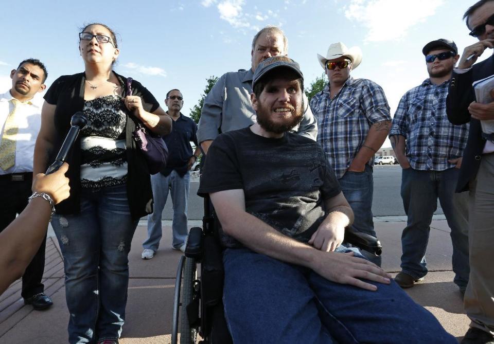 Caleb Medley, center, who was shot in the face in the 2012 Aurora movie theater massacre, sits in a wheelchair near his wife, Katie, front left, and other family members as they talk with the media after attending the reading of the verdict in the trial of shooter James Holmes at the Arapahoe County District Court, in Centennial, Colo., Thursday, July 16, 2015. (Photo: AP Photo/Brennan Linsley)