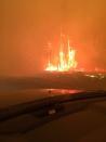 Fire burns near a road in Fort McMurray, Alberta on Tuesday May 3, 2016. THE CANADIAN PRESS/Holly Ayearst