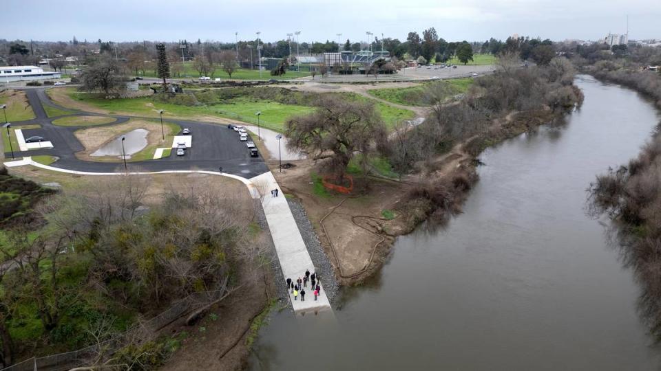 A group of local and state officials tour the new boat ramp on the Tuolumne river at Tuolumne River Regional Park in Modesto, Calif., Wednesday, Feb. 7, 2024. John Thurman Field, home to the Modesto Nuts minor-league baseball team, can be seen across Neece Drive from the park.