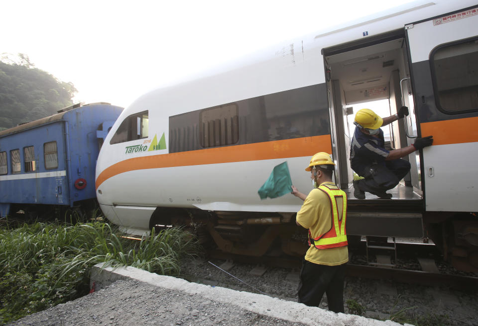 A worker checks on the derailed train near Taroko Gorge in Hualien, Taiwan on Saturday, April 3, 2021. The train partially derailed in eastern Taiwan on Friday after colliding with an unmanned vehicle that had rolled down a hill, killing and injuring dozens. (AP Photo/Chiang Ying-ying)