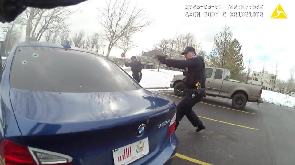 In this image taken from from police body-worn camera video provided by the Farmington City, Utah, Police Department, police officers hold up their weapons during a traffic stop, Wednesday, March 1, 2023, in Farmington, Utah. The footage released by the suburban police department in Utah on Wednesday, Mach 8, 2023, shows five officers opening rounds of fire into all sides of a car after they can be heard alerting each other that the driver, 25-year-old Chase Allan, has a gun. The Allan family has since raised questions about police actions. (Farmington City Police Department via AP)