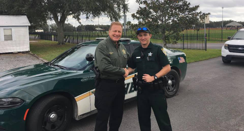 A photograph of a Florida police officer comforting an injured dog hit by car has gone viral.