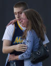 Jacob Stevens, 18, hugs his mother Tammi Stevens after being interview by police outside Gateway High School where witness were brought for questioning after a shooting at a movie theater, Friday, July 20, 2012 in Denver. A gunman wearing a gas mask set off an unknown gas and fired into a crowded movie theater at a midnight opening of the Batman movie "The Dark Knight Rises," killing at least 12 people and injuring at least 50 others, authorities said. (AP Photo/Barry Gutierrez)