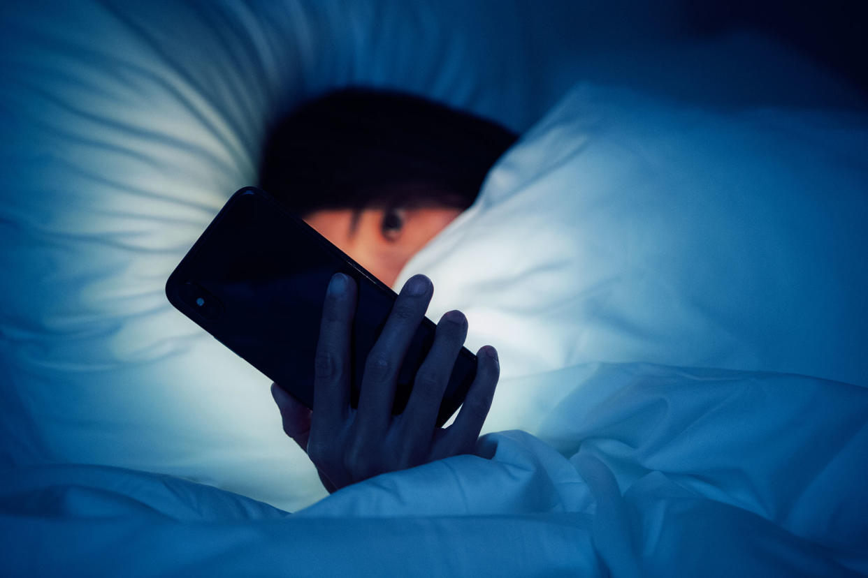 Woman using smart phone late at night Getty Images/Oscar Wong