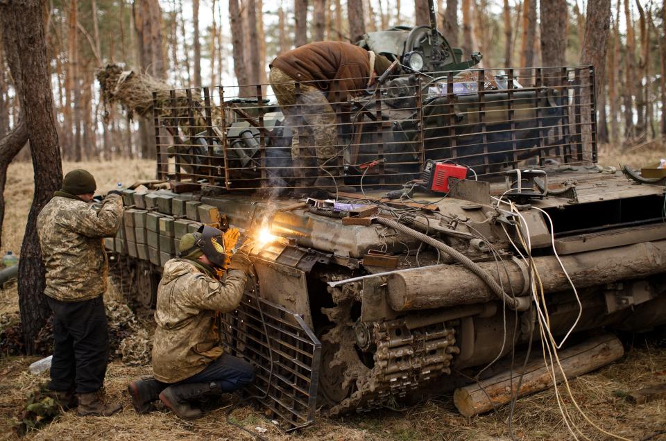 A repair battalion soldier of the Armed Forces of Ukraine welds slat armor onto a T-64 tank in Donetsk Oblast, Ukraine.