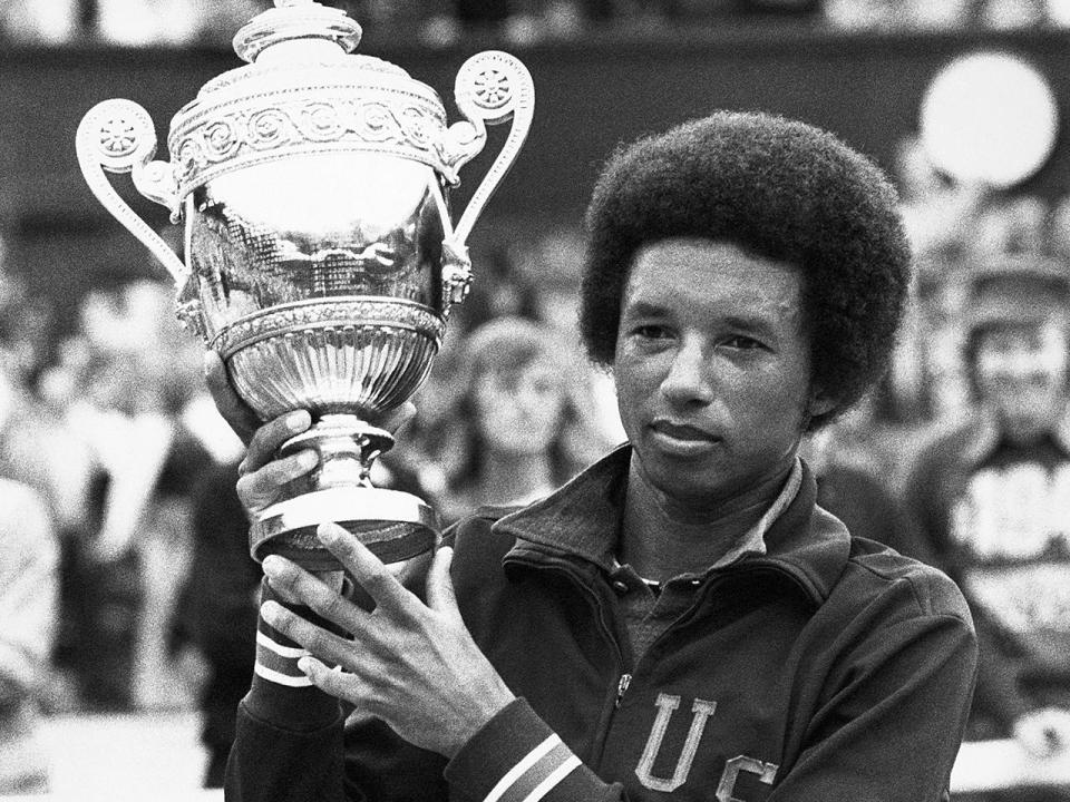 Arthur Ashe holds up his trophy after defeating Jimmy  Connors at the Wimbledon Tennis Championship in July 1975 in London,  England.  / Credit: © Hulton-Deutsch Collection/CORBIS/Corbis via Getty Images