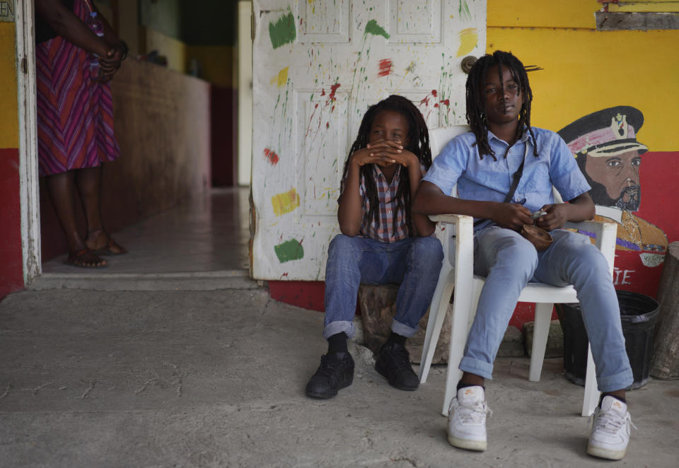 Brothers Blessing and Zion, members of the Ras Freeman Foundation for the Unification of Rastafari, wait for service to start in the tabernacle on Sunday, May 14, 2023, in Liberta, Antigua. (AP Photo/Jessie Wardarski)