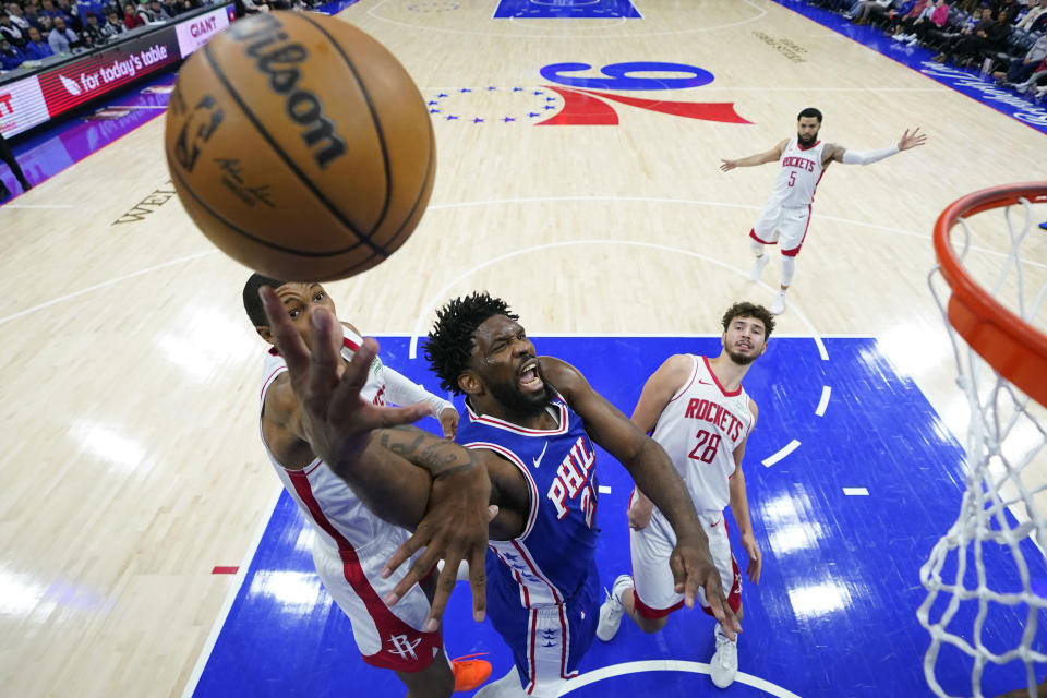 Philadelphia 76ers' Joel Embiid, center, goes up for a shot between Houston Rockets' Jabari Smith Jr., left, and Alperen Sengun during the second half of an NBA basketball game, Monday, Jan. 15, 2024, in Philadelphia. (AP Photo/Matt Slocum)