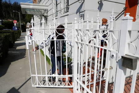 An unidentified woman enters a gate at the side entrance to the building of the Consulate General of Russia in San Francisco, California, U.S., August 31, 2017. REUTERS/Stephen Lam